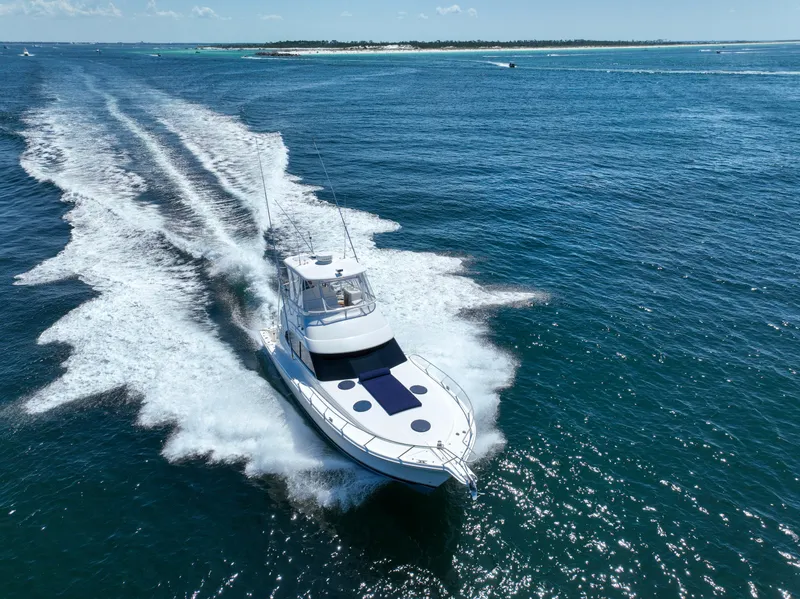 Slide: The Image of 2007 Riviera 42 Flybridge yacht cruising on open blue ocean waters. - 23