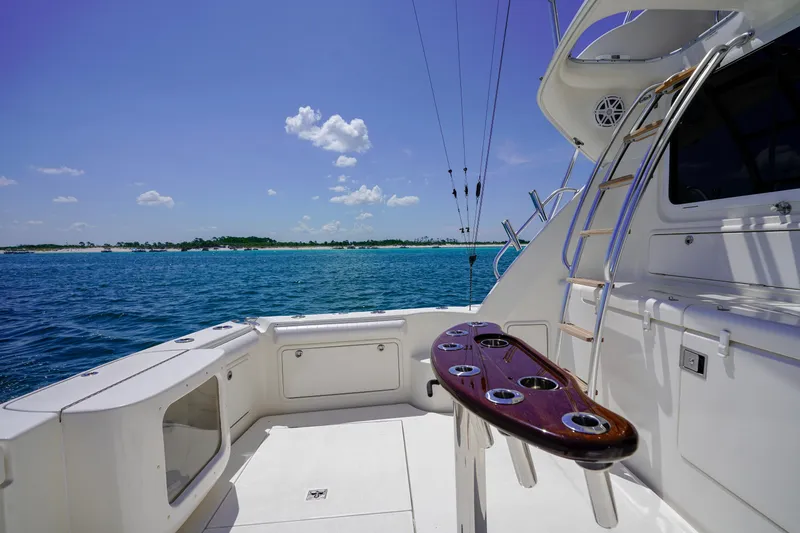 Slide: The Image of 2007 Riviera 42 Flybridge yacht deck with ocean view, featuring fishing rod holders. - 24