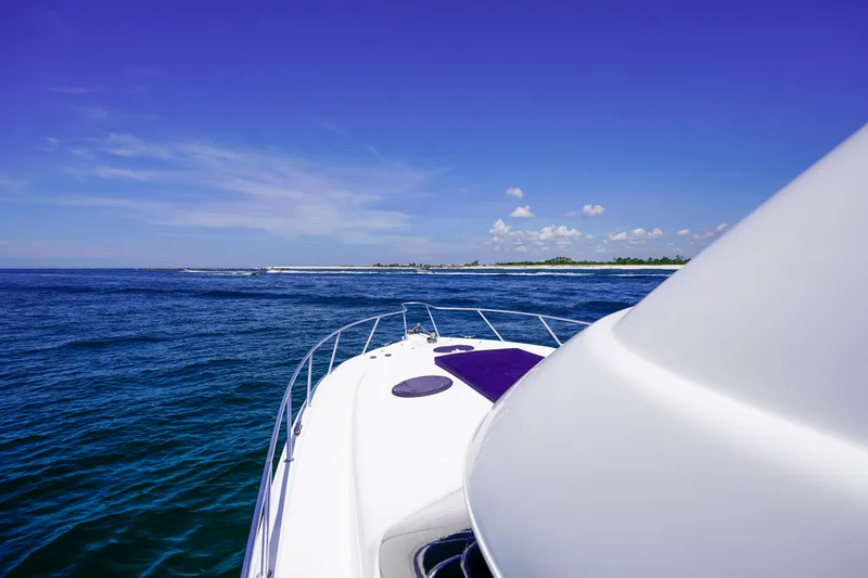 Slide: The Image of 2007 Riviera 42 Flybridge yacht cruising on open blue sea under clear sky. - 32