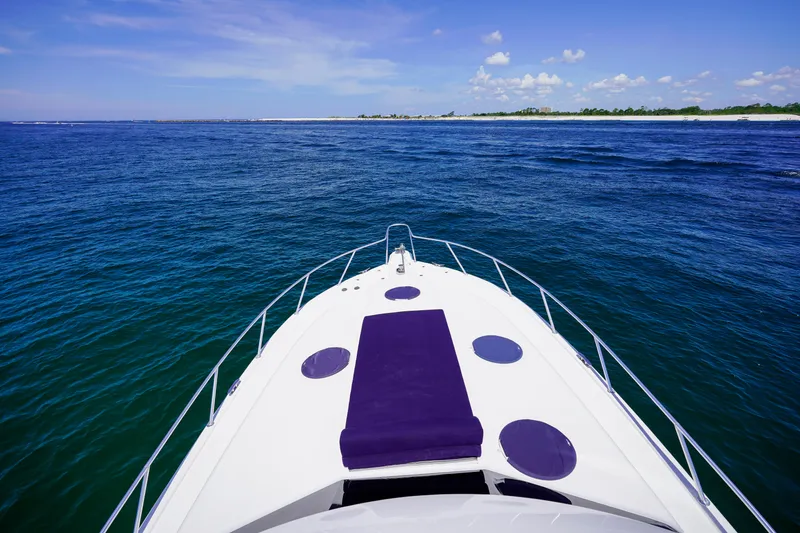 Slide: The Image of Bow view of 2007 Riviera 42 Flybridge yacht on open sea under clear blue sky. - 33