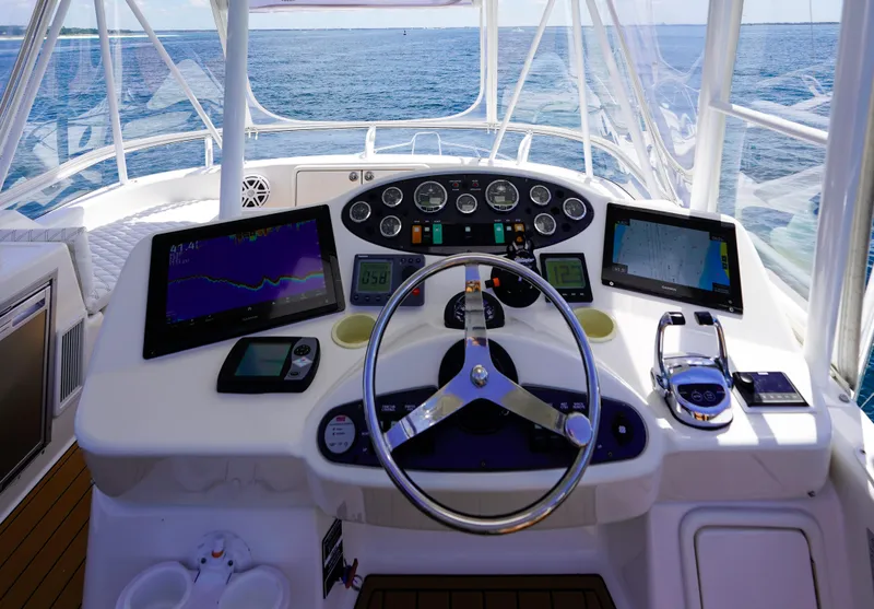 Slide: The Image of Helm of 2007 Riviera 42 Flybridge yacht with navigation screens and controls. - 38