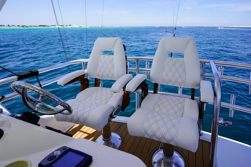Slide: The Image of Flybridge of 2007 Riviera 42 yacht with two white captain chairs overlooking the ocean. - 41