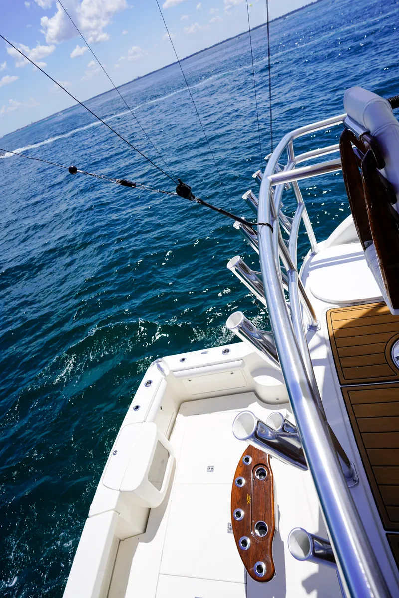 Slide: The Image of Riviera 42 Flybridge 2007 yacht deck with fishing rods, ocean view, and clear blue sky. - 43