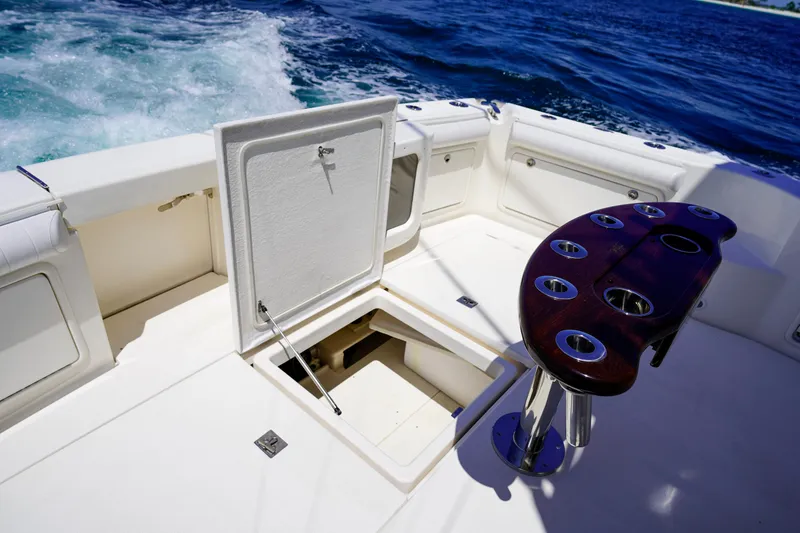 Slide: The Image of 2007 Riviera 42 Flybridge yacht deck with open hatch and rod holders, cruising on blue ocean. - 46