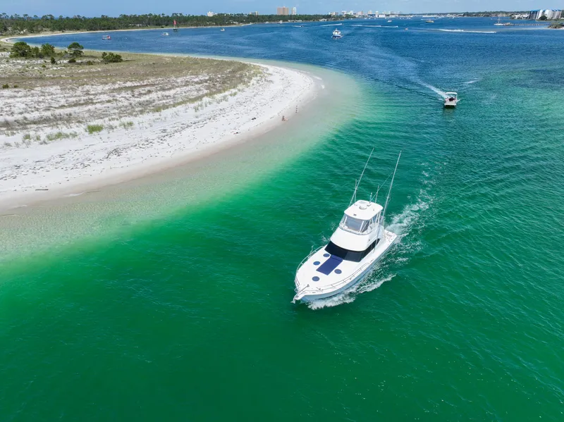 Slide: The Image of Aerial view of 2007 Riviera 42 Flybridge cruising near a sandy shoreline. - 5