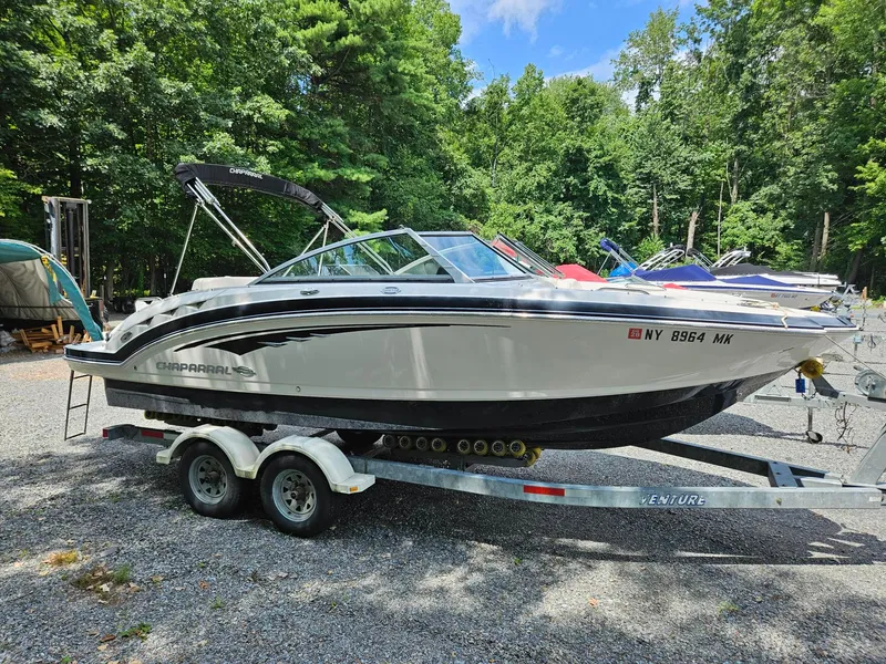 The Image of 2014 Chaparral 224 Sunesta boat on trailer in wooded area. - 0