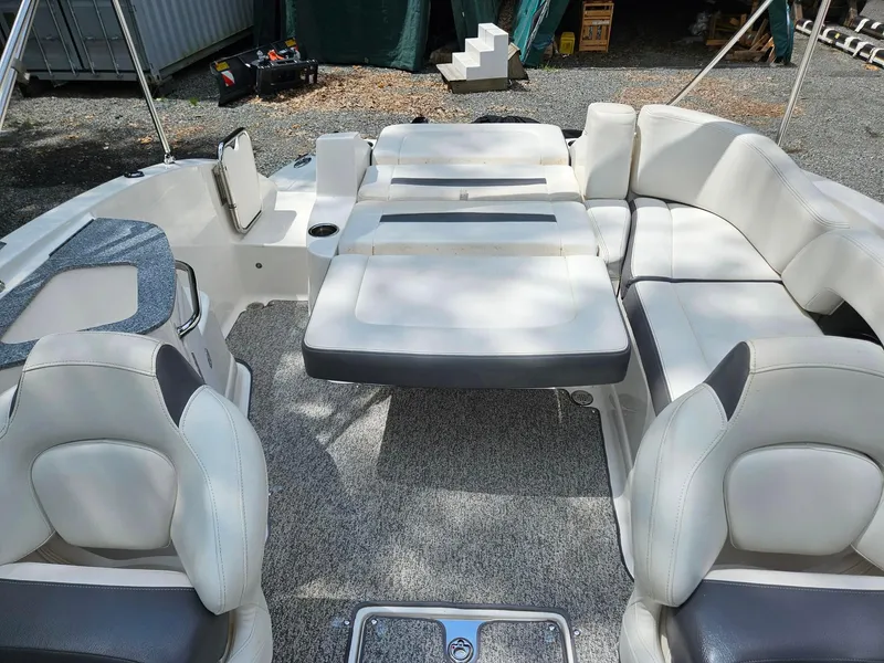 Slide: The Image of 2014 Chaparral 224 Sunesta boat interior with white seating and gray carpet. - 11