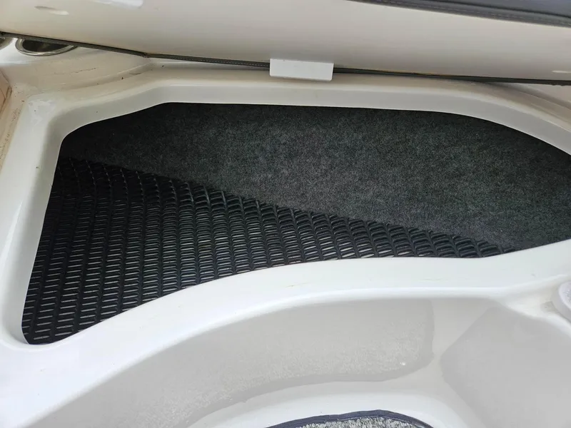 Slide: The Image of Storage compartment of a 2014 Chaparral 224 Sunesta boat, featuring a carpeted interior. - 25