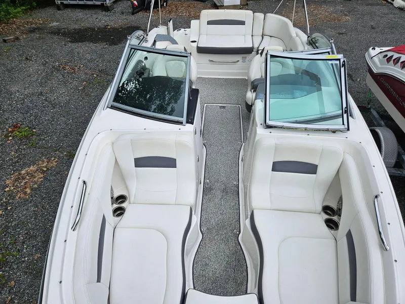 Slide: The Image of 2014 Chaparral 224 Sunesta boat interior with white seating and open windshield. - 32