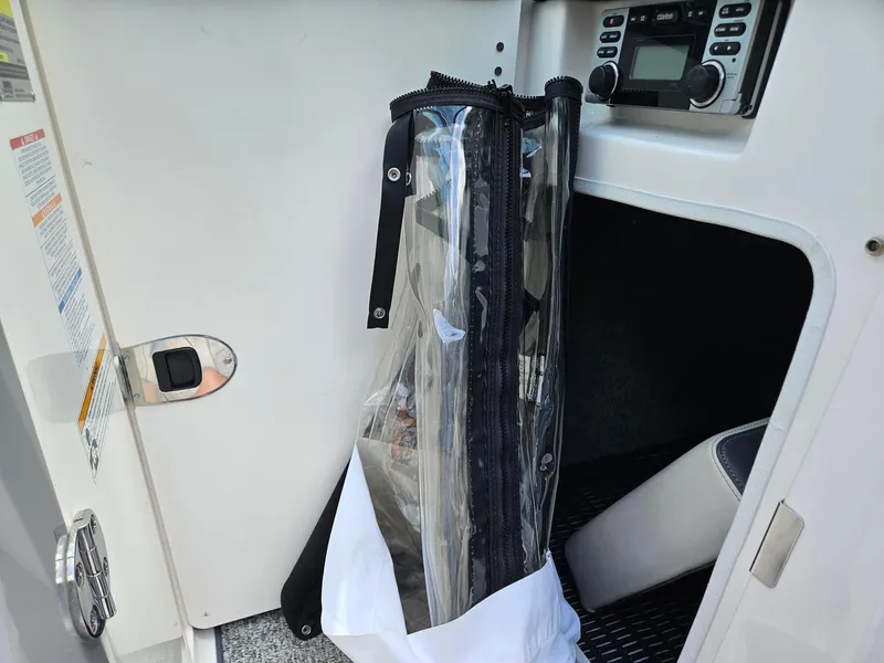 Slide: The Image of Storage compartment in 2014 Chaparral 224 Sunesta boat with clear plastic cover and stereo system. - 34