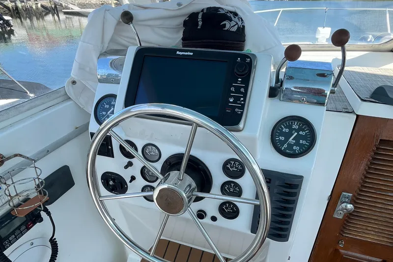Slide: The Image of 1976 Uniflite 28 Salty Dog helm with steering wheel, gauges, and navigation equipment. - 11