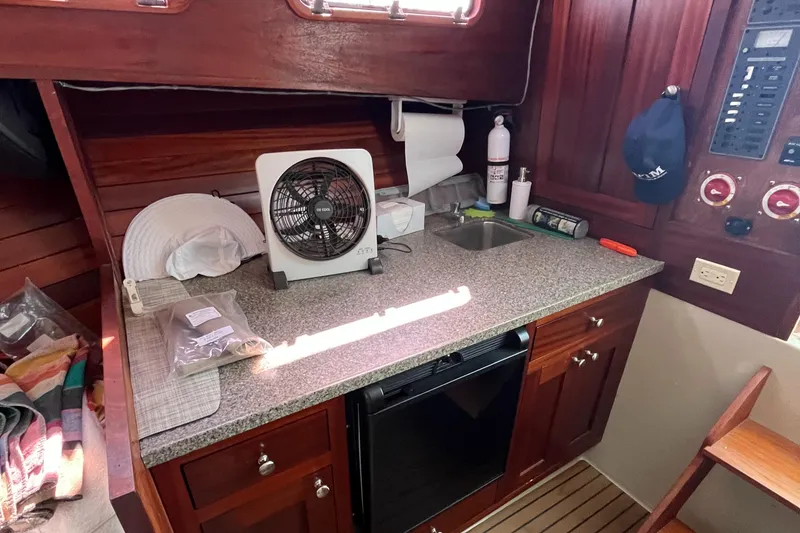 Slide: The Image of 1976 Uniflite 28 Salty Dog interior with countertop, fan, and wooden cabinetry. - 15