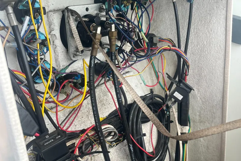 Slide: The Image of Tangled wiring inside a 1976 Uniflite 28 Salty Dog boat, showcasing complex electrical connections. - 16