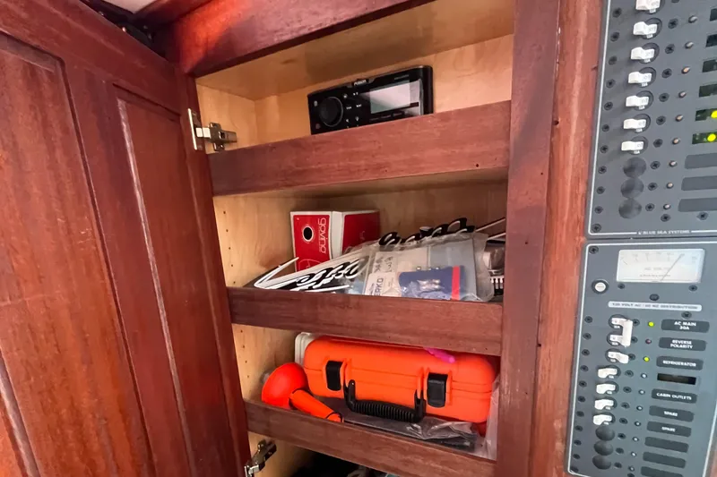 Slide: The Image of Wooden cabinet with shelves, radio, and equipment on a 1976 Uniflite 28 Salty Dog boat. - 19