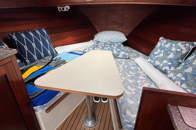 Slide: The Image of 1976 Uniflite 28 Salty Dog cabin interior with cozy bedding and a central table. - 21