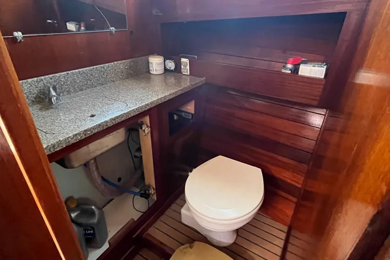 Slide: The Image of 1976 Uniflite 28 Salty Dog boat bathroom with wooden interior and granite countertop. - 23