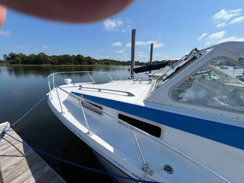 Slide: The Image of 1976 Uniflite 28 Salty Dog boat docked on a sunny day, calm water background. - 3