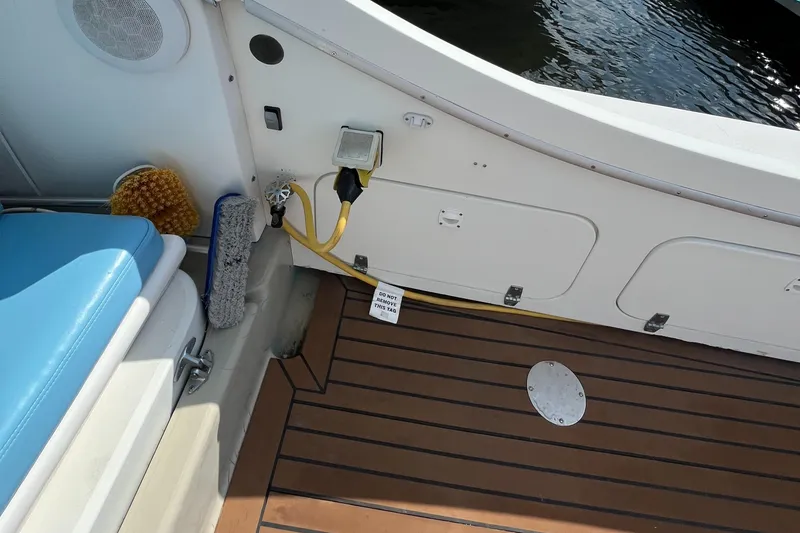 Slide: The Image of 1976 Uniflite 28 Salty Dog boat deck with seating, cleaning tools, and electrical connections. - 46