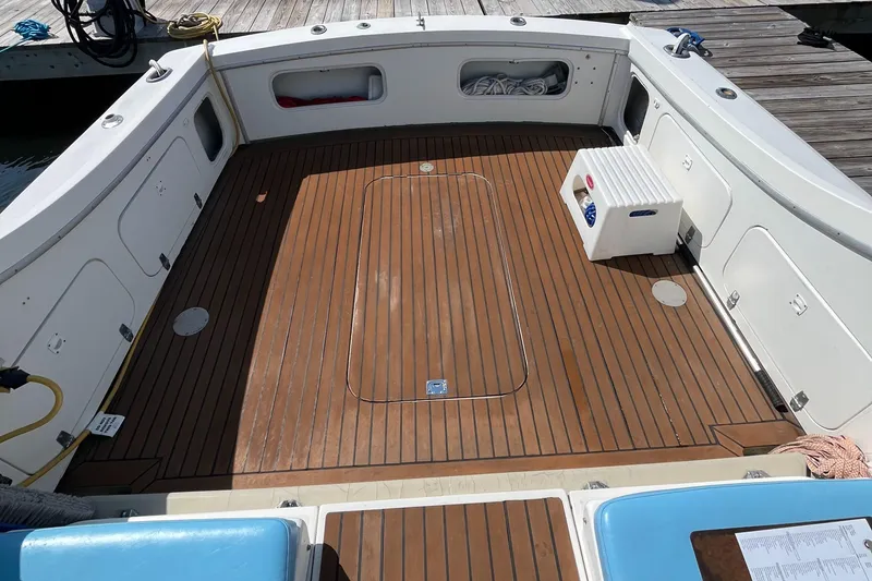 Slide: The Image of 1976 Uniflite 28 Salty Dog boat deck with wood finish and storage compartments. - 6