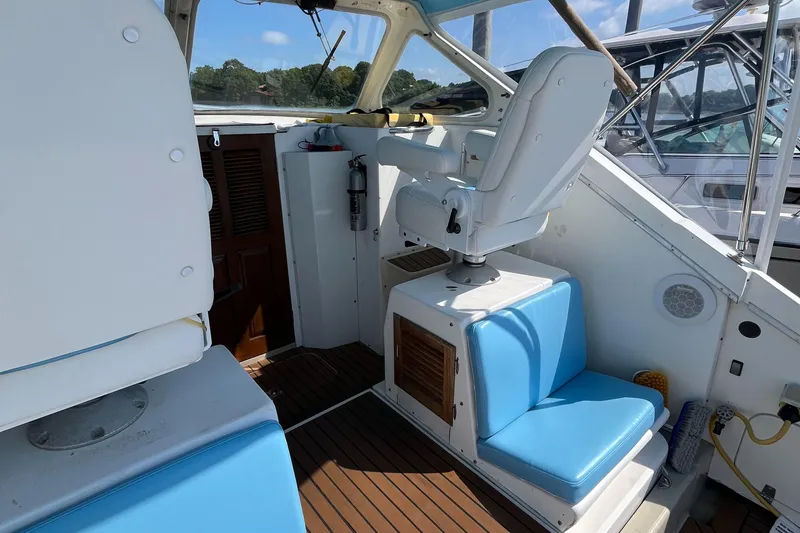 Slide: The Image of 1976 Uniflite 28 Salty Dog boat interior with blue seating and wooden flooring. - 8