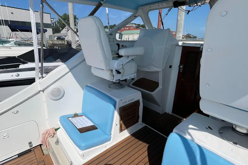 Slide: The Image of 1976 Uniflite 28 Salty Dog boat interior with blue seating and wooden flooring. - 9