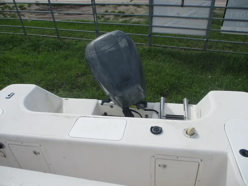 Slide: The Image of Century 2300 Center Console boat, 2000 model, with outboard motor, parked on grass. - 12