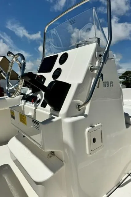 Slide: The Image of 2026 Key West 179 FS boat console with steering wheel and controls under a clear sky. - 12