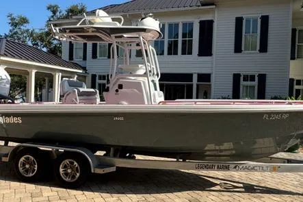 Slide: The Image of 2018 Everglades 243CC boat on trailer, parked in front of a house. - 13