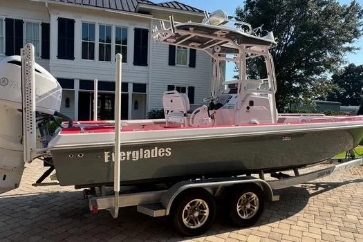 Slide: The Image of 2018 Everglades 243CC boat on trailer, parked in front of a house. - 14