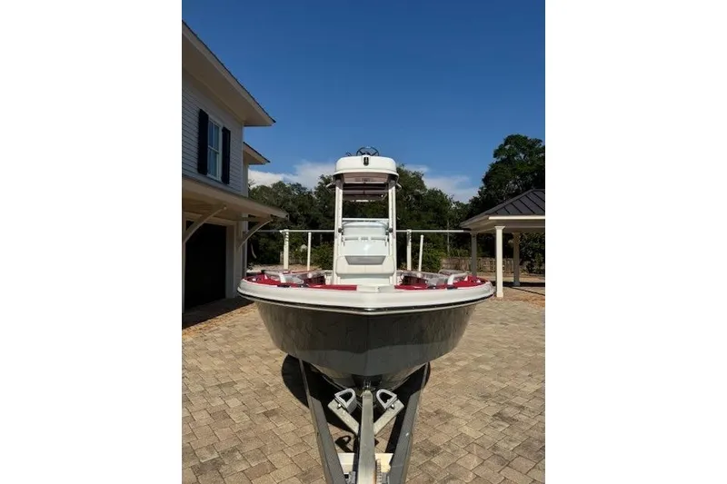 Slide: The Image of 2018 Everglades 243CC boat on trailer in driveway, clear sky background. - 18