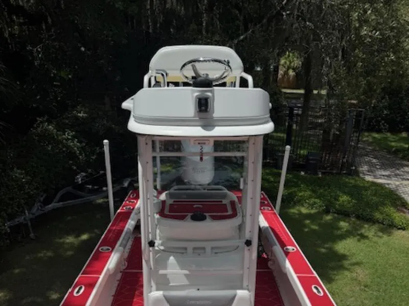 Slide: The Image of 2018 Everglades 243CC boat with red and white interior, parked outdoors. - 9