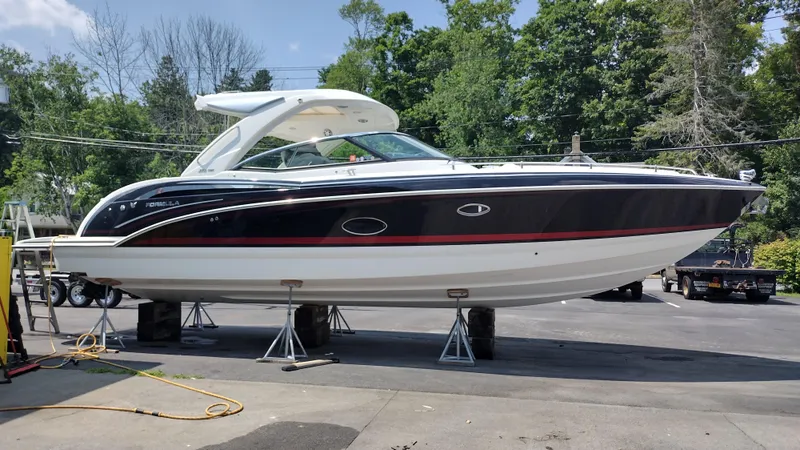 Slide: The Image of 2020 Formula 350 CBR boat on stands, outdoors, surrounded by trees and equipment. - 4