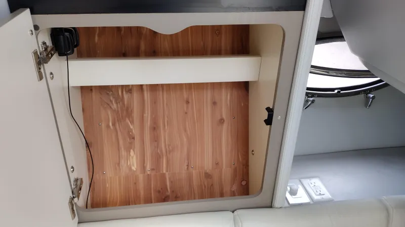 Slide: The Image of 2020 Formula 350 CBR interior storage compartment with wooden finish and electrical outlet. - 41