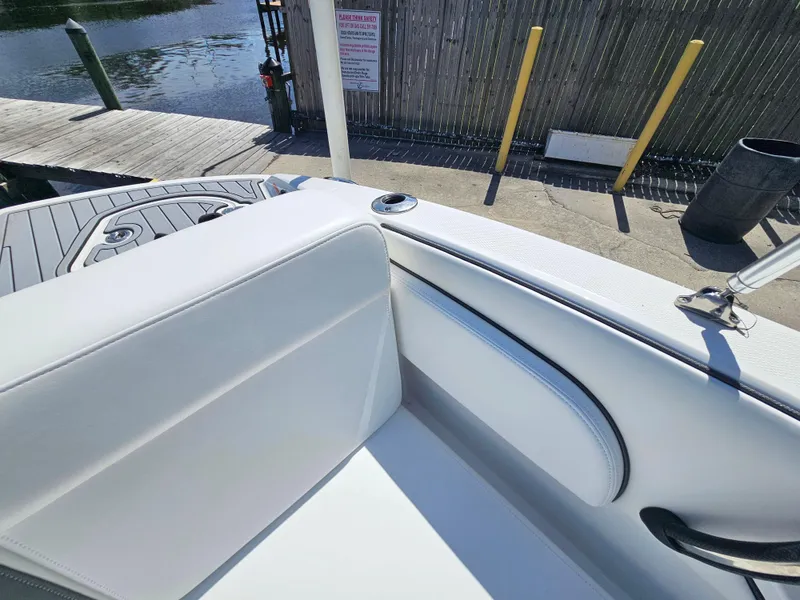 Slide: The Image of 2017 Monterey 217 Outboard boat interior with white seating near a dock. - 27