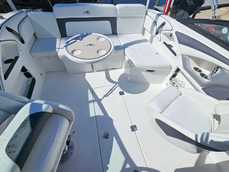 Slide: The Image of 2017 Monterey 217 Outboard boat interior with white seating and round table. - 38
