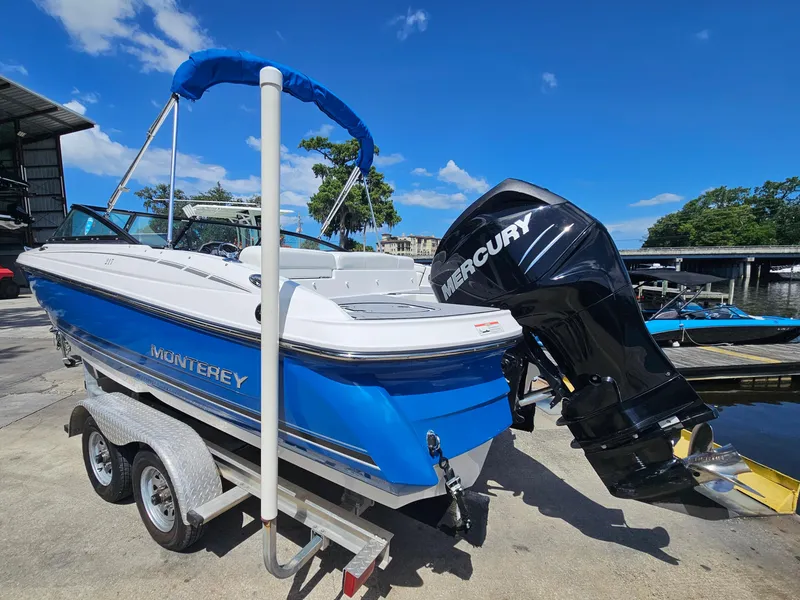 Slide: The Image of 2017 Monterey 217 Outboard boat with Mercury engine on trailer, under clear blue sky. - 6