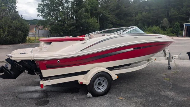 Slide: The Image of 2006 Sea Ray 185 Sport boat on trailer, red and white design, parked outdoors. - 11