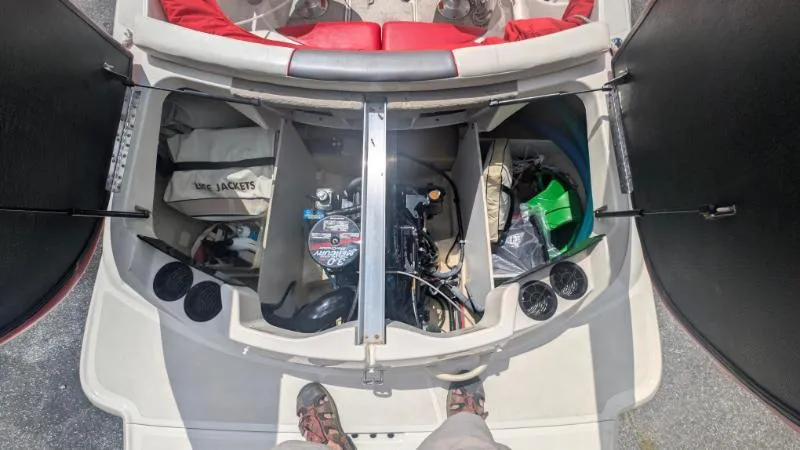 Slide: The Image of 2006 Sea Ray 185 Sport engine compartment with storage and life jackets. - 2