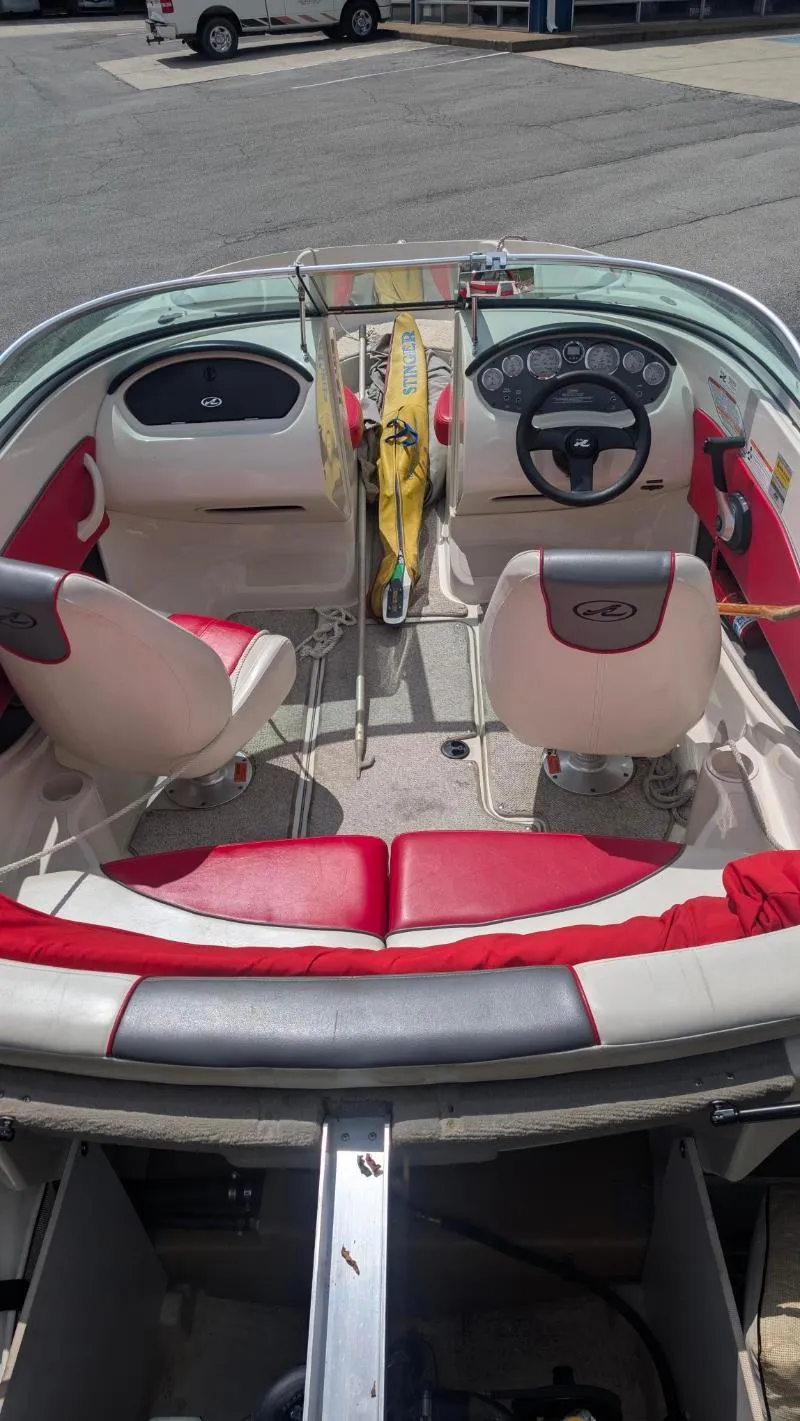 Slide: The Image of 2006 Sea Ray 185 Sport boat interior with red and white seating, steering wheel, and dashboard. - 6