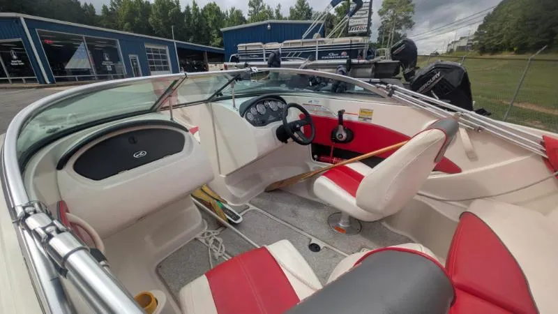 Slide: The Image of 2006 Sea Ray 185 Sport boat interior with red and white seating, dashboard, and steering wheel. - 7