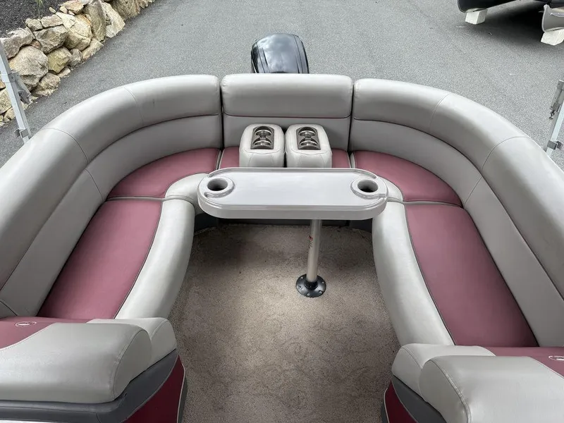 Slide: The Image of 2015 Premier 250 Solaris pontoon boat interior with cushioned seating and table. - 12