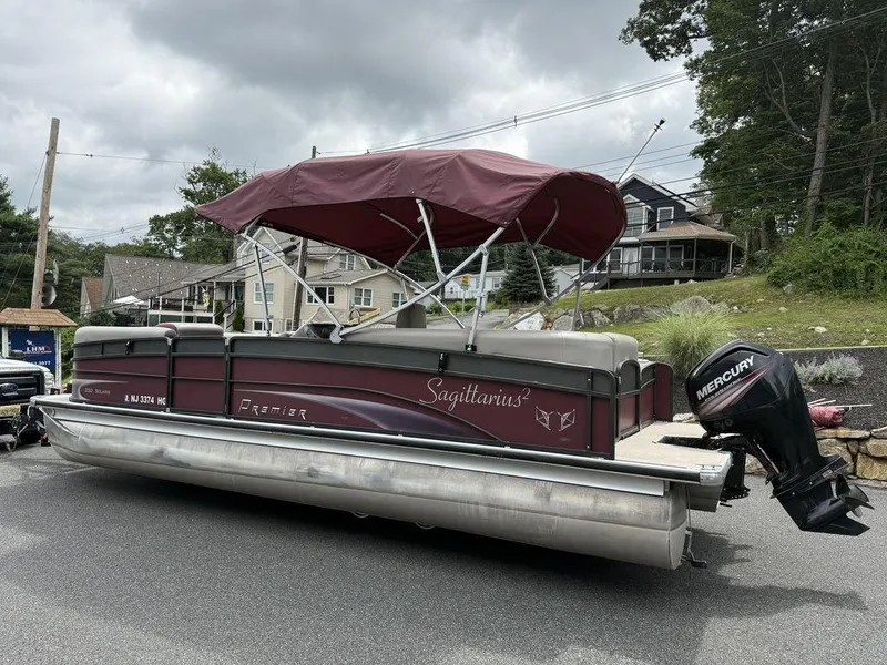 Slide: The Image of 2015 Premier 250 Solaris pontoon boat with maroon canopy and Mercury outboard motor. - 3