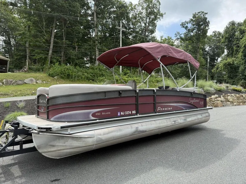 Slide: The Image of 2015 Premier 250 Solaris pontoon boat with maroon canopy, parked on a road. - 7