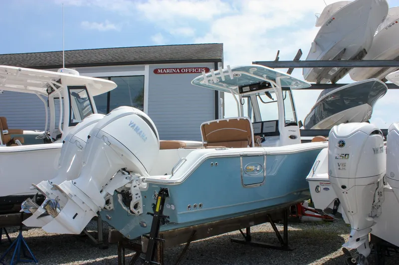 Slide: The Image of 2026 Sea Hunt Ultra 265 SE boat with Yamaha engines at marina office. - 13