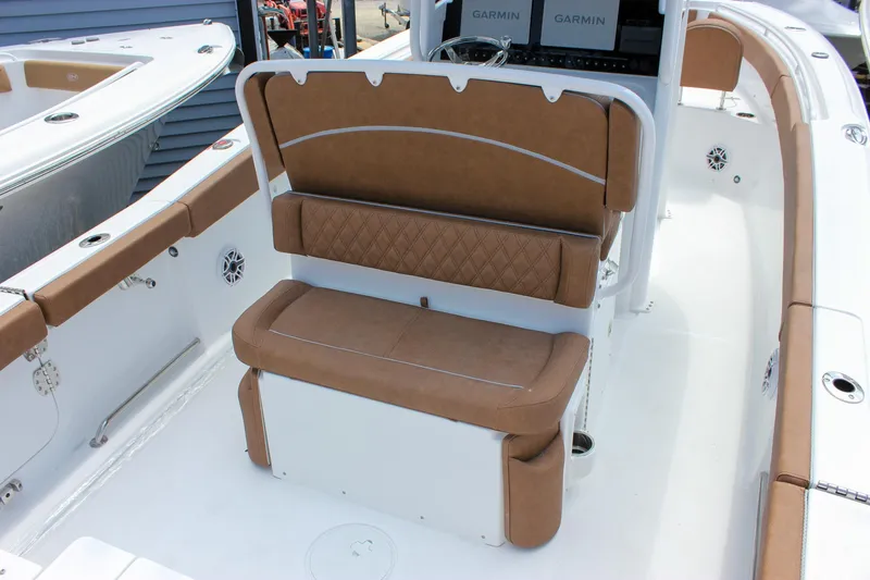 Slide: The Image of 2026 Sea Hunt Ultra 265 SE boat interior with brown cushioned seating and Garmin displays. - 18