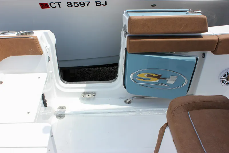 Slide: The Image of 2026 Sea Hunt Ultra 265 SE boat interior with brown seating and storage compartment. - 20