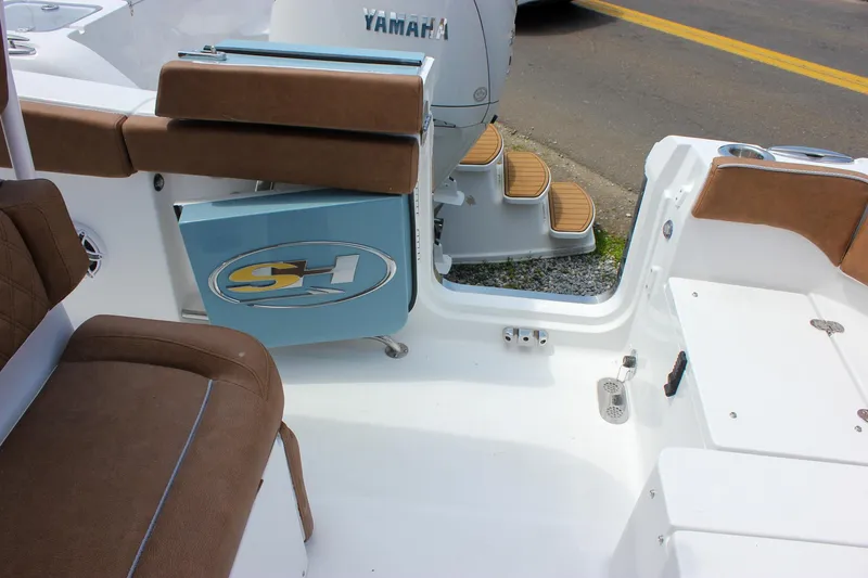Slide: The Image of 2026 Sea Hunt Ultra 265 SE boat interior with brown seating and Yamaha engine. - 21