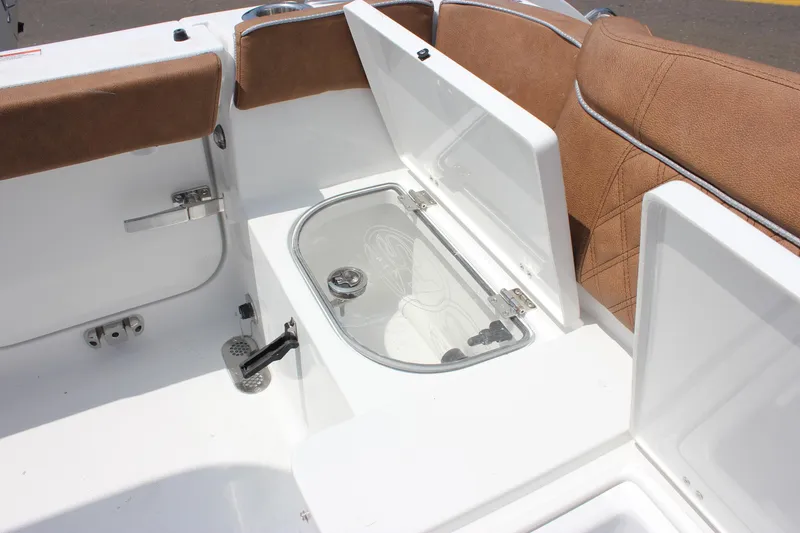 Slide: The Image of 2026 Sea Hunt Ultra 265 SE boat interior with brown seating and storage compartment. - 25