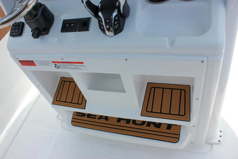 Slide: The Image of 2026 Sea Hunt Ultra 265 SE boat console with controls and branded mat. - 30