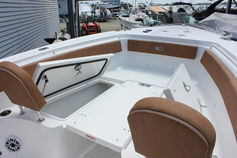 Slide: The Image of 2026 Sea Hunt Ultra 265 SE boat interior with open storage compartments and cushioned seating. - 34